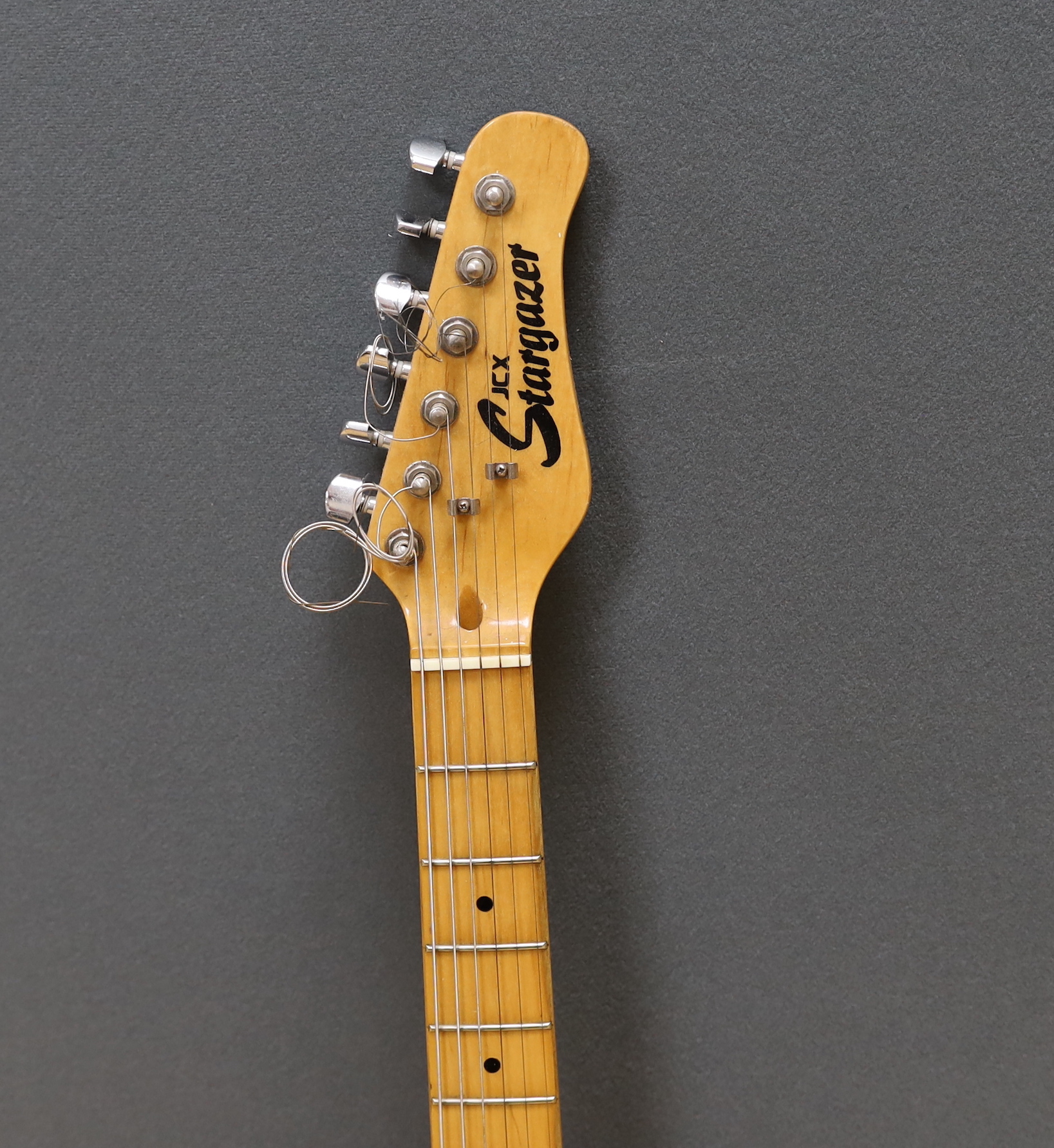 A JCX Stargazer electric guitar with maple neck and orange lacquered body